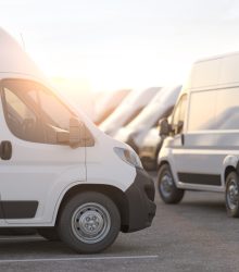 Express delivery, shipping service concept. Delivery vans in a row in the rays of sunset or dawn. 3d illustration