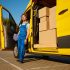 Male courier providing cargo delivery or home office moving service. Deliveryman standing at parked shipping van loaded with cardboard boxes